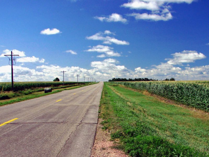 a highway surrounded by cornfields