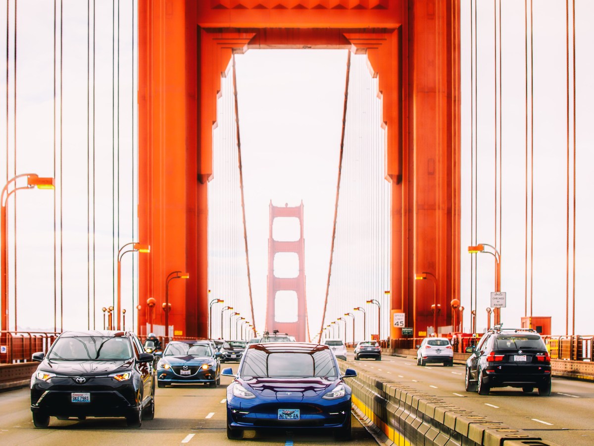 A Tesla and other cars drive across the Golden Gate bridge